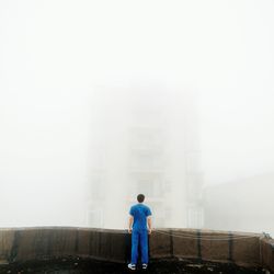 Woman standing in foggy weather