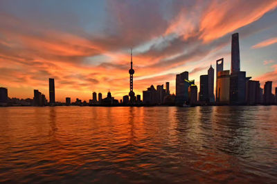 View of city at waterfront during sunset