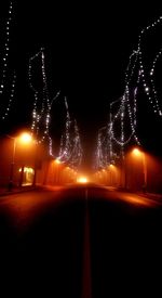 Illuminated tunnel at night