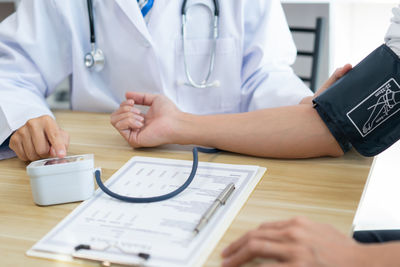 Midsection of doctor examining patient at clinic