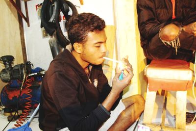 Young man looking at food while sitting on display
