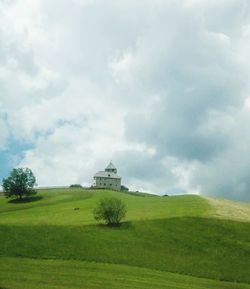 Scenic view of grassy field against cloudy sky