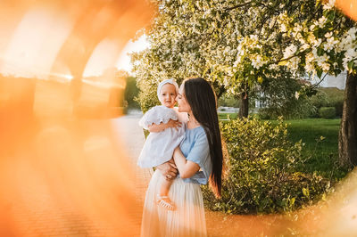 Rear view of woman standing against trees
