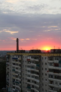 Buildings in city against sky during sunset