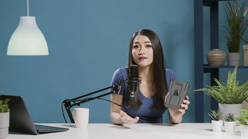 Portrait of woman podcasting in studio