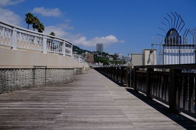 Footpath amidst buildings against sky
