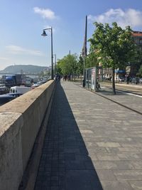 Sidewalk in city against sky