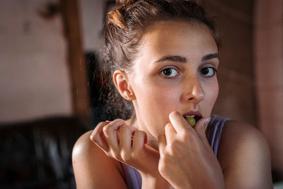 Close-up portrait of teenage girl eating grape