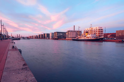 City by sea against sky at dusk