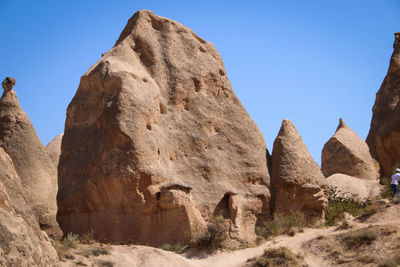 Low angle view of rocks against clear blue sky