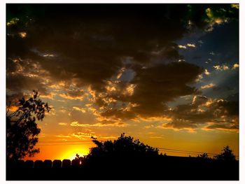 Silhouette of building against cloudy sky during sunset