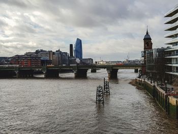 Bridge over river against buildings in city