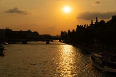 Bridge over river against sky during sunset