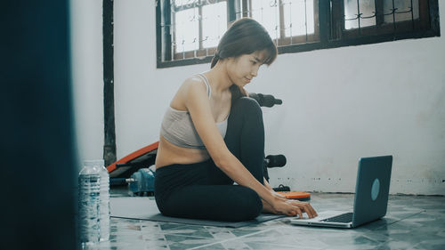 Woman using mobile phone while sitting on table