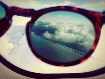 Close-up of sunglasses against sky