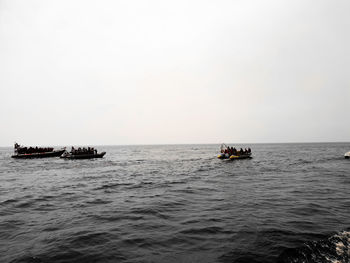 Boat sailing in sea against clear sky