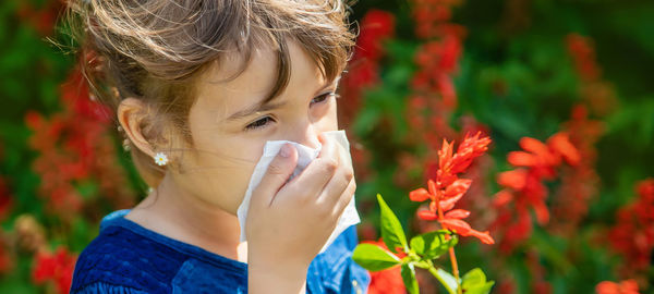 Sick girl having allergy wiping nose