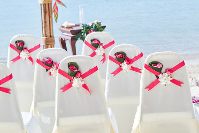 Empty chairs arranged at beach during celebration