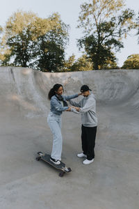 Teenage girl learning how to skate in skate park