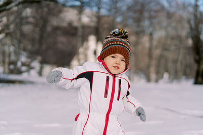 Portrait of boy standing on snow covered field