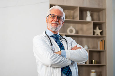 Portrait of young man standing against wall