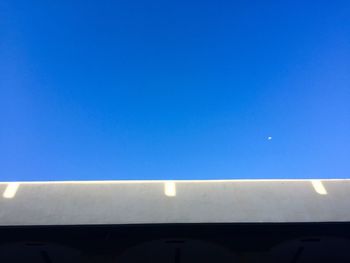 Low angle view of airplane against clear blue sky