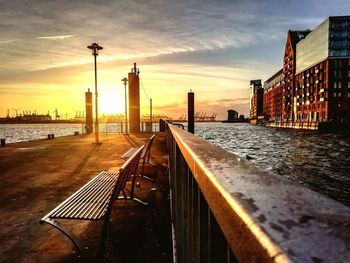 View of buildings at waterfront against cloudy sky