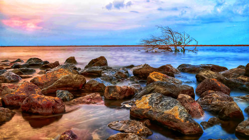 Rocks in sea against sky