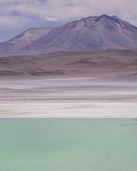 Scenic view of lake and mountains against cloudy sky