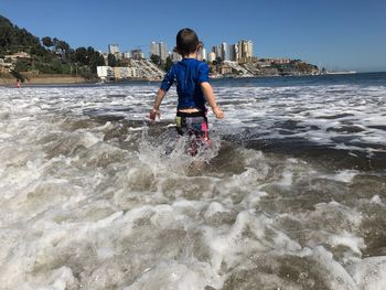 Full length of boy in sea against sky