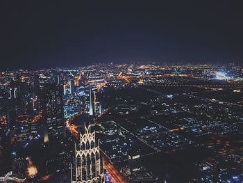 Illuminated cityscape against sky at night