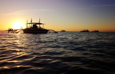 Sailboat in sea against sky during sunset