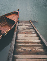 High angle view of rowboat by wooden steps in lake