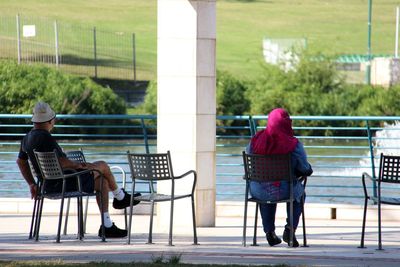 Rear view of couple sitting on bench