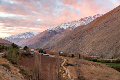 Scenic view of mountains against cloudy sky during sunset