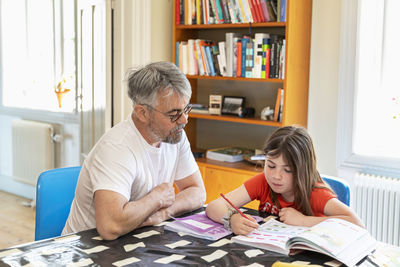 Father helping daughter with homework