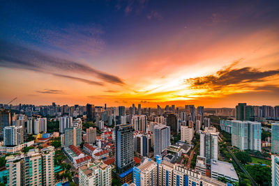 Modern buildings against sky during sunset