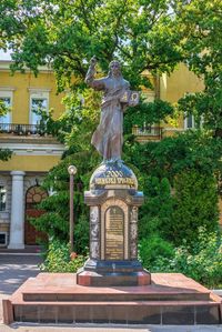 Statue against trees and building