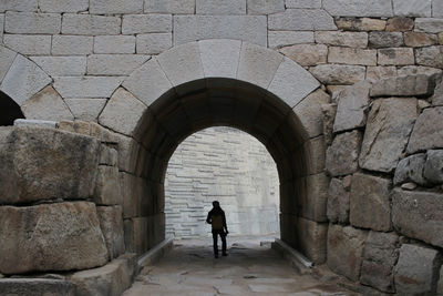 Rear view of man walking against wall