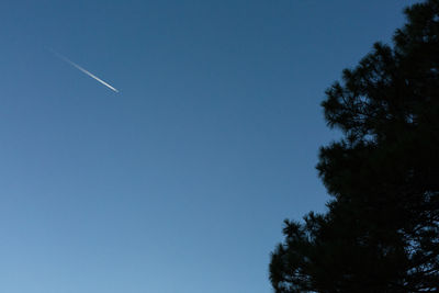 Low angle view of vapor trail against clear blue sky