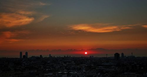 High angle view of silhouette buildings against sky during sunset