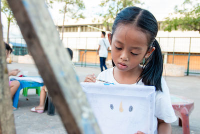 Cute girl painting on paper