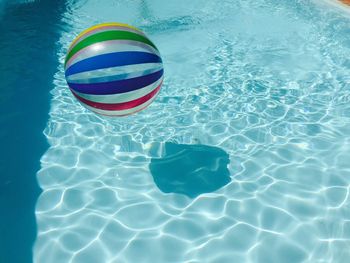 High angle view of stripped balll on rippled water in swimming pool