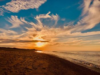 Scenic view of beach against sky during sunset