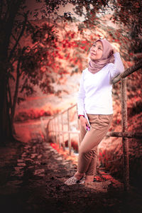 Portrait of woman standing on footpath