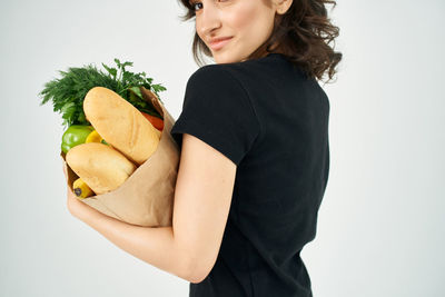 Midsection of woman holding ice cream against white background