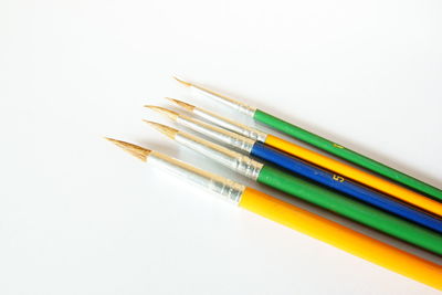 High angle view of colored pencils against white background