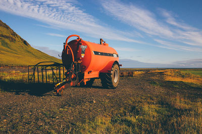 Agricultural machinery in farm against sky on sunny day