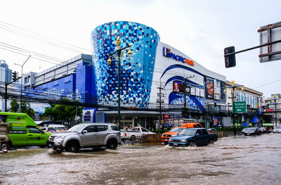 Cars on road against blue sky in city