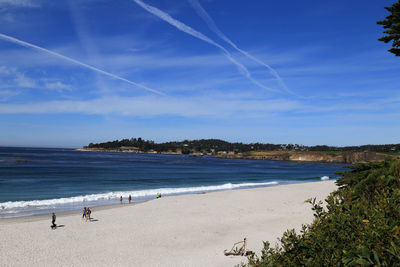 Scenic view of sea against vapor trails in sky